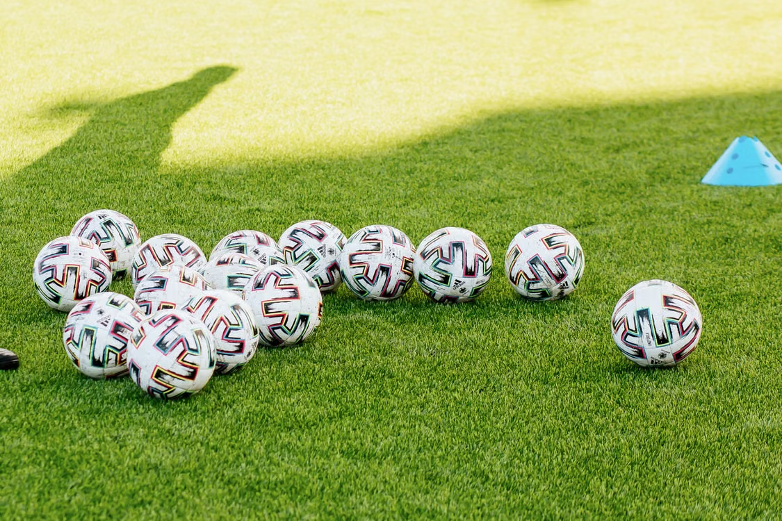 Balones de fútbol sobre el césped durante un entrenamiento